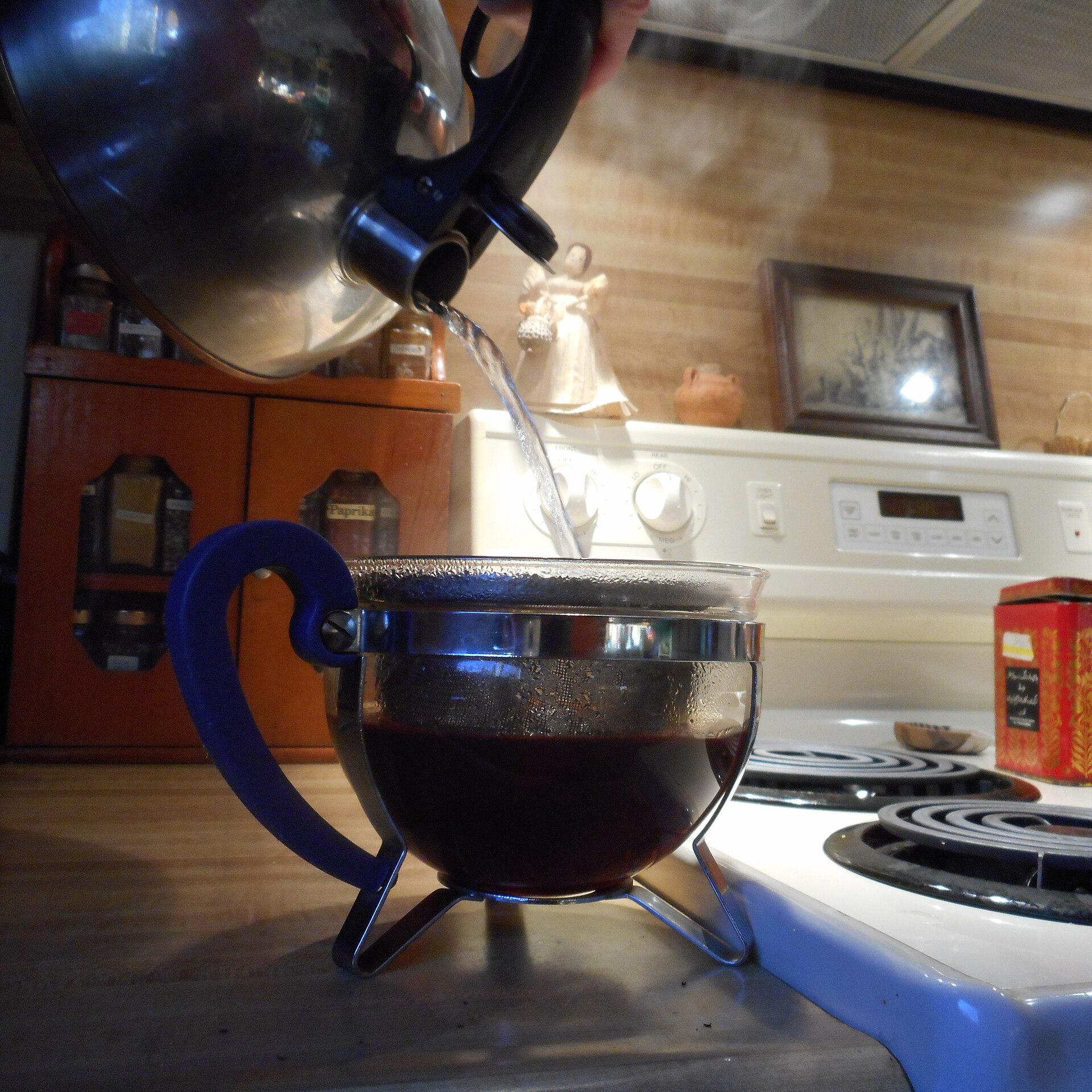 Hot water being poured from a kettle into a teapot