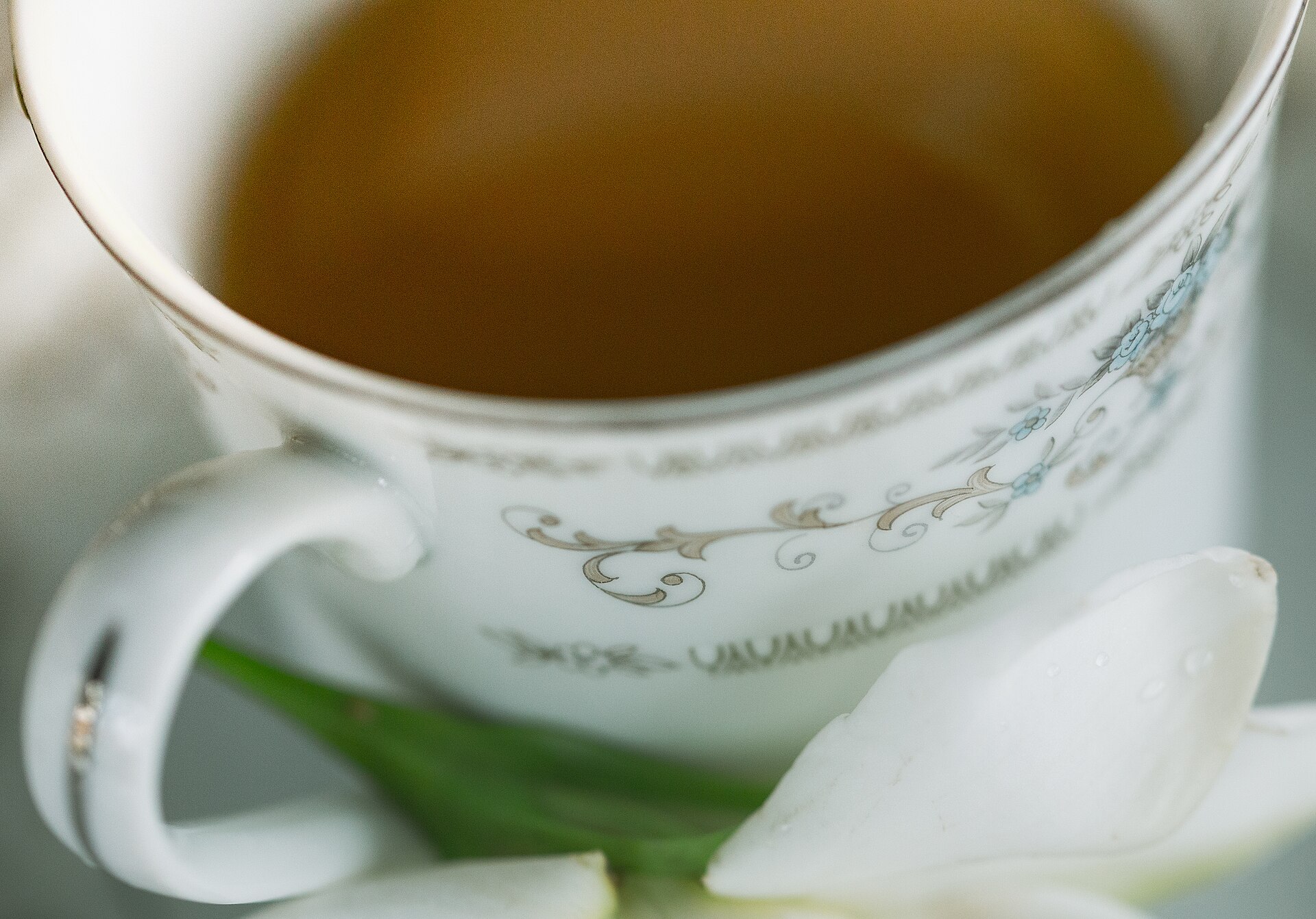 Someone cupping a small bowl of tea to smell its aroma
