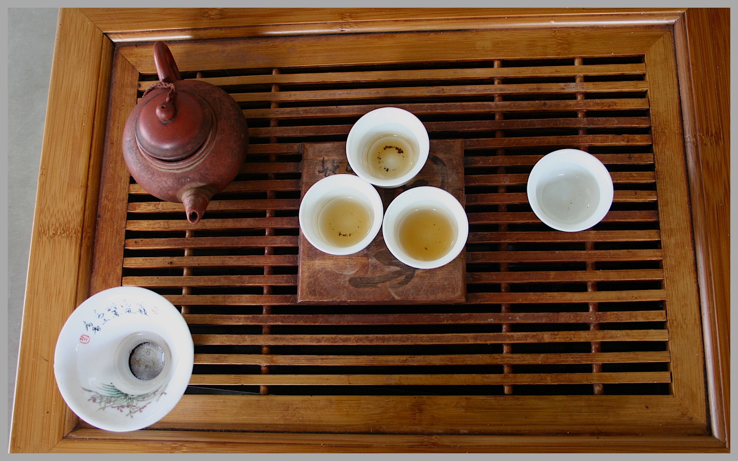 A traditional tea gathering with a ceramic teapot and small cups