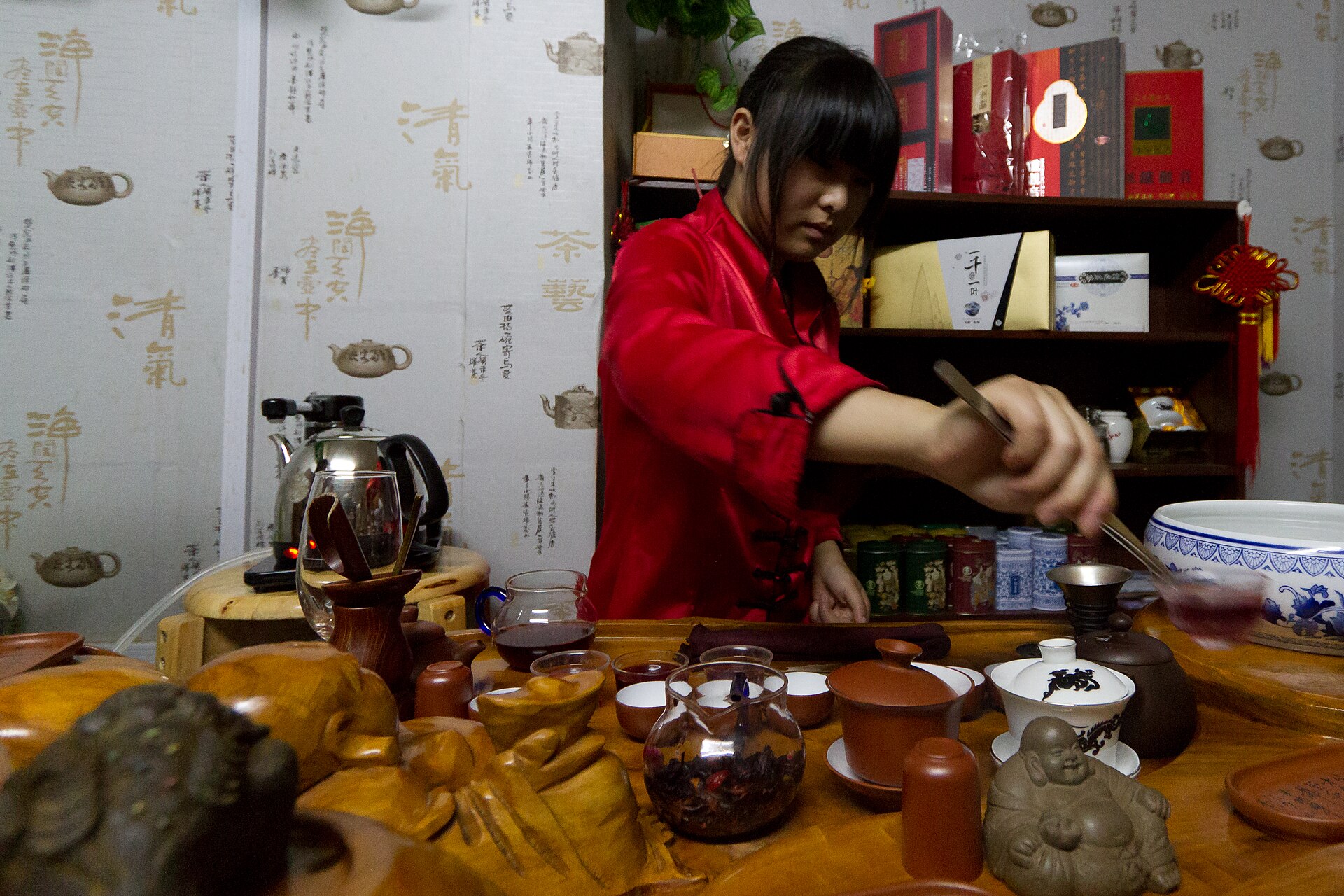 A tea master pouring tea from a small clay pot into cups during a Chinese tea ceremony