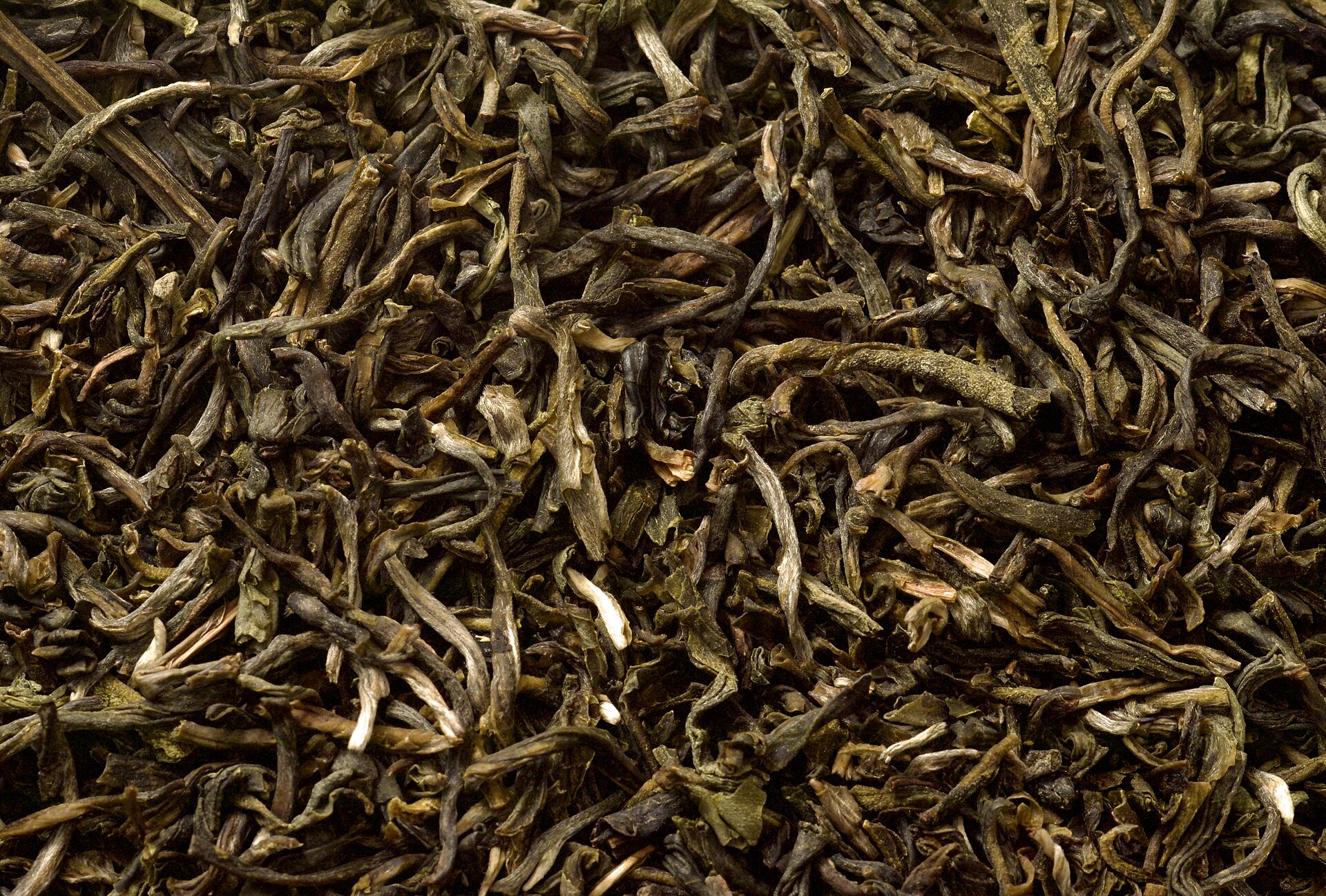 Someone smelling a handful of dry tea leaves