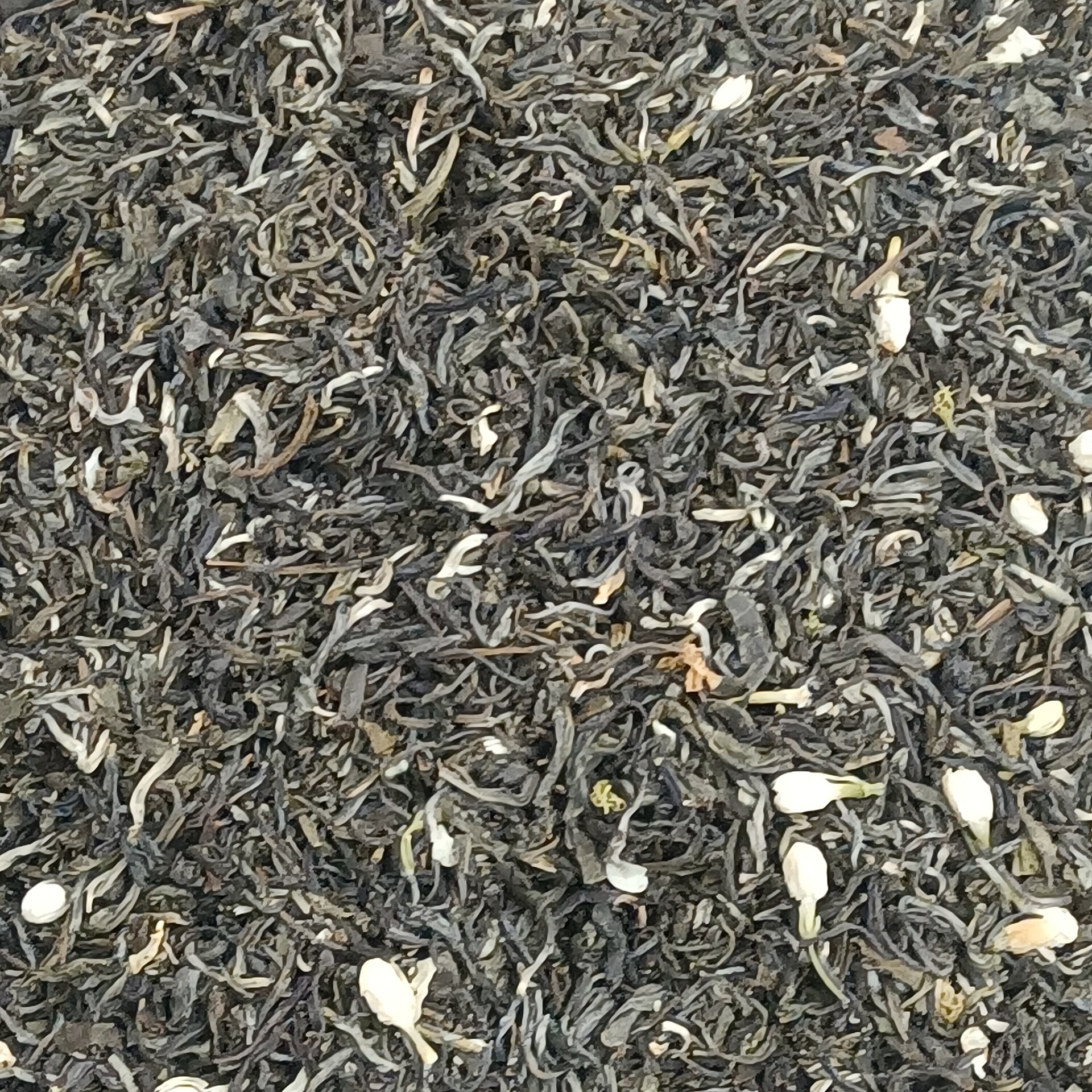 A cup of pale tea beside fresh flowers