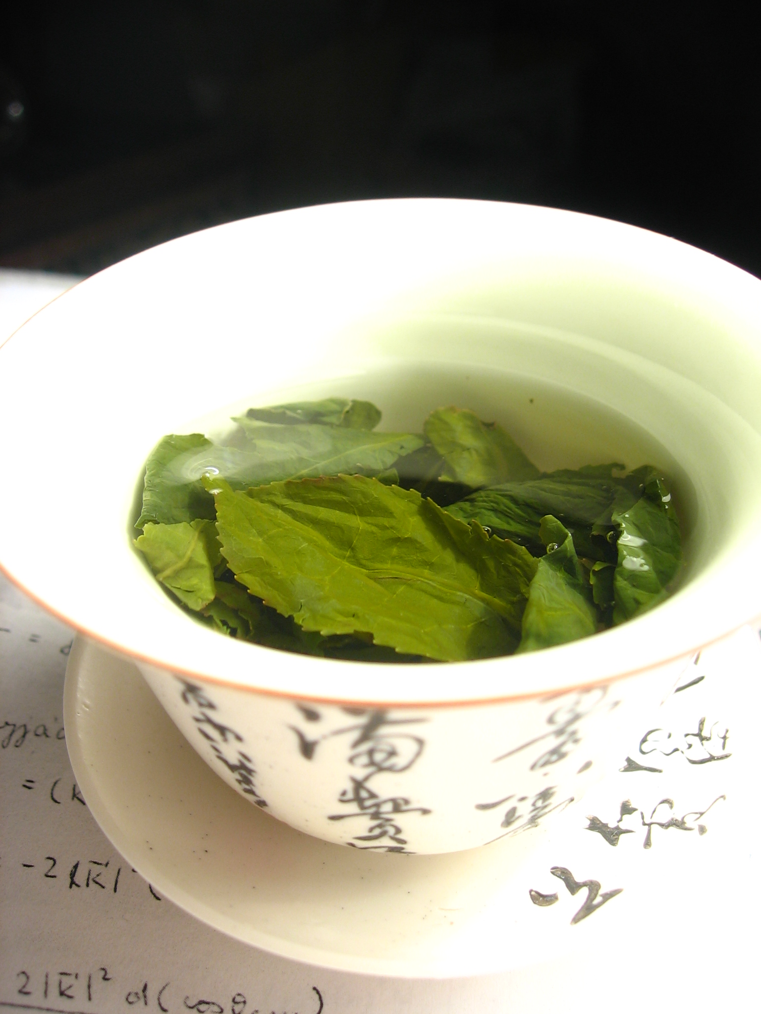 Loose tea leaves steeping inside a porcelain gaiwan