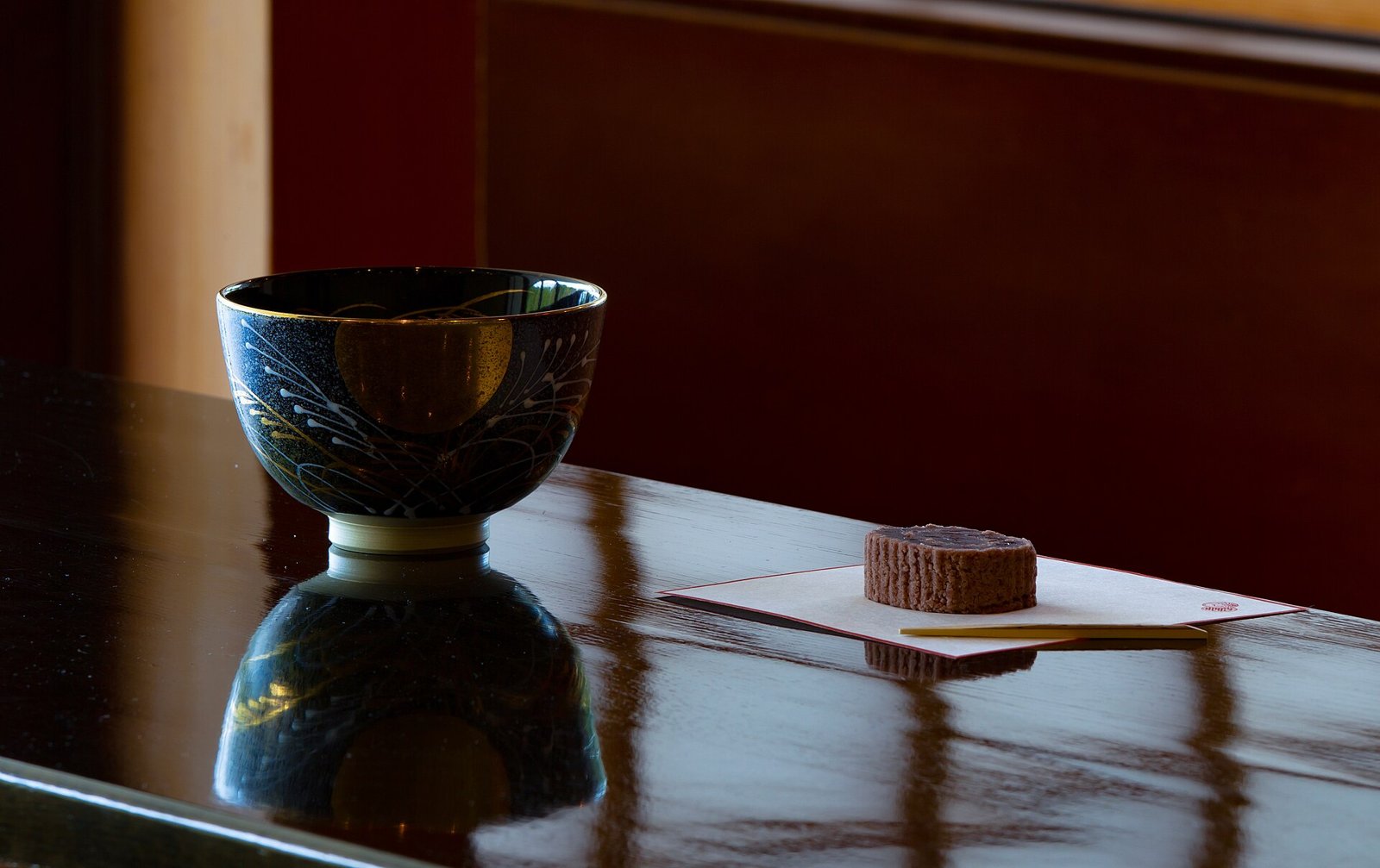 A matcha bowl and bamboo whisk at a teahouse in a Japanese garden