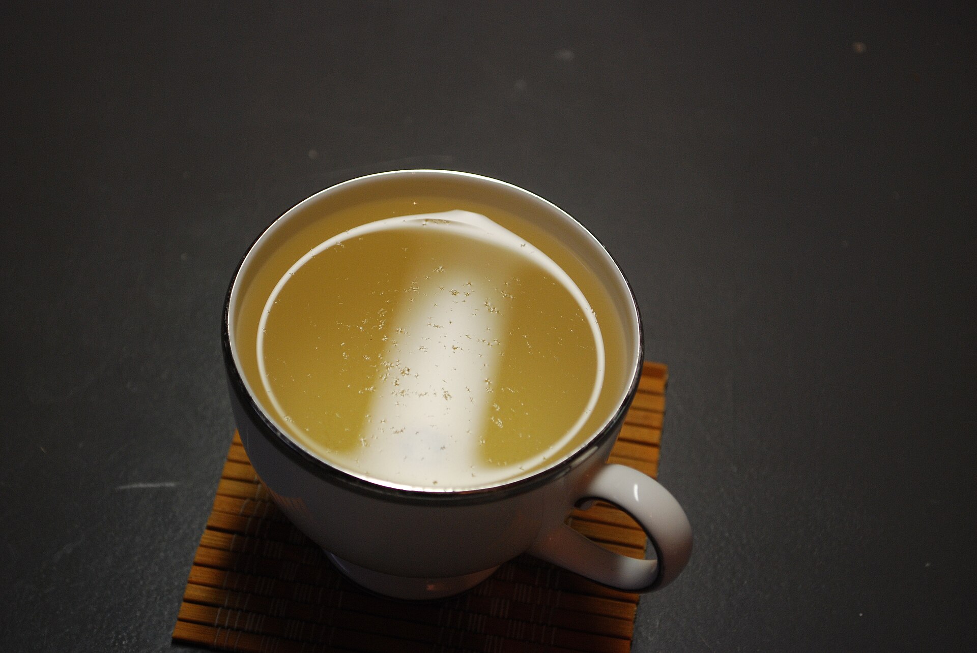 Silvery white tea buds next to green tea leaves